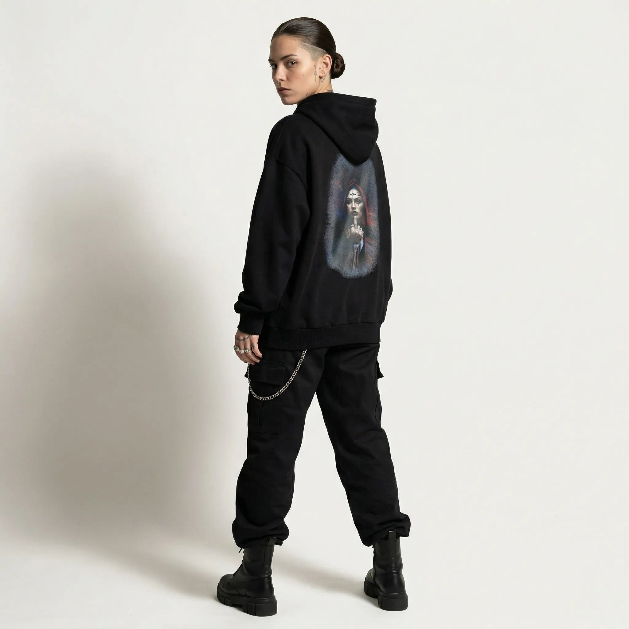 Person wearing a black hoodie with a graphic design on the back against a plain background