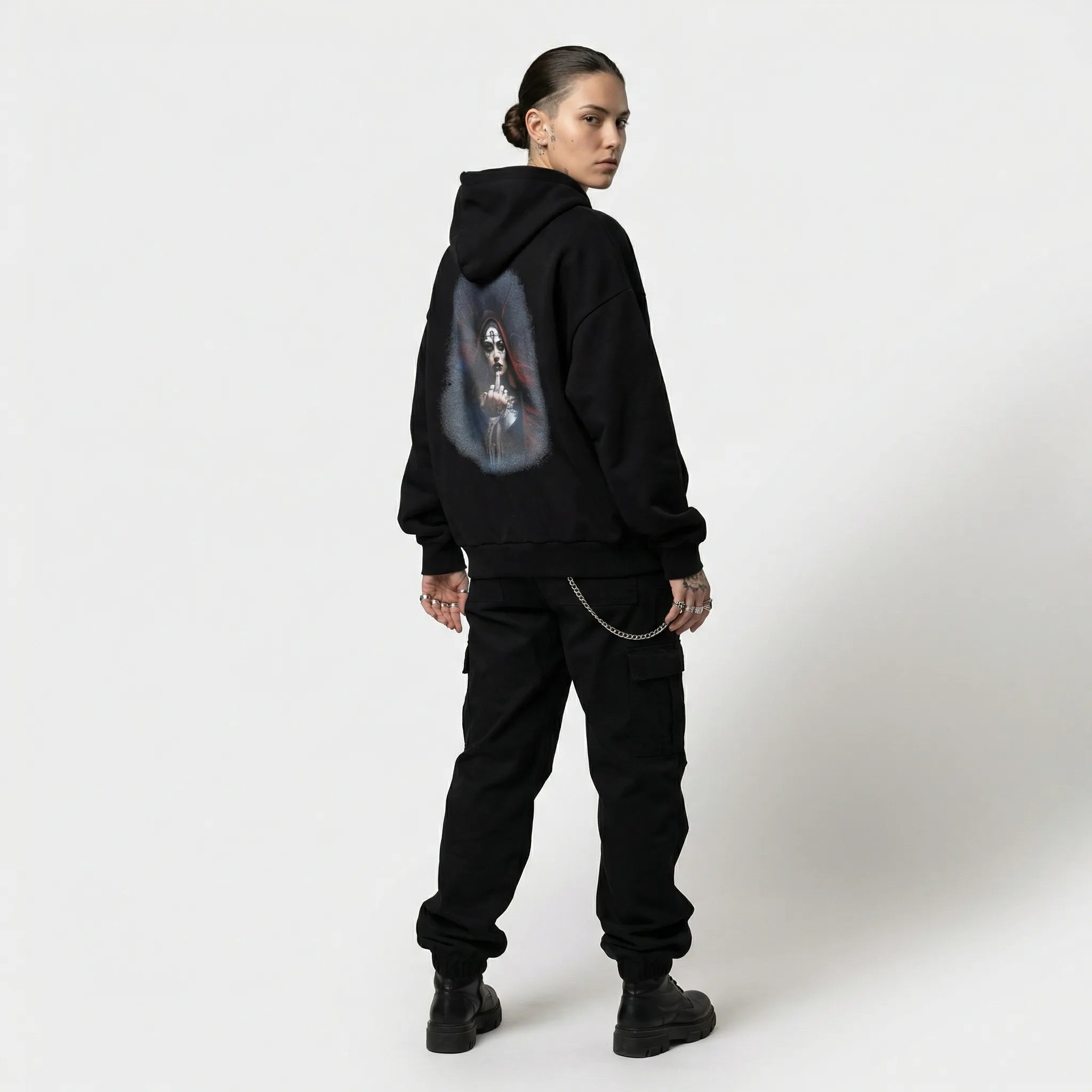 Person wearing a black hoodie with a graphic design on the back against a white background