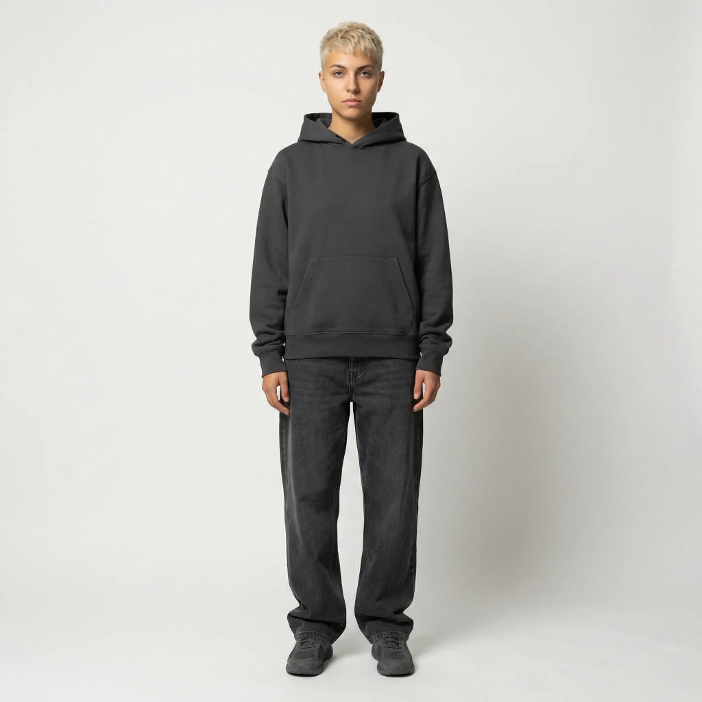 Person wearing a dark gray hoodie and pants on a white background