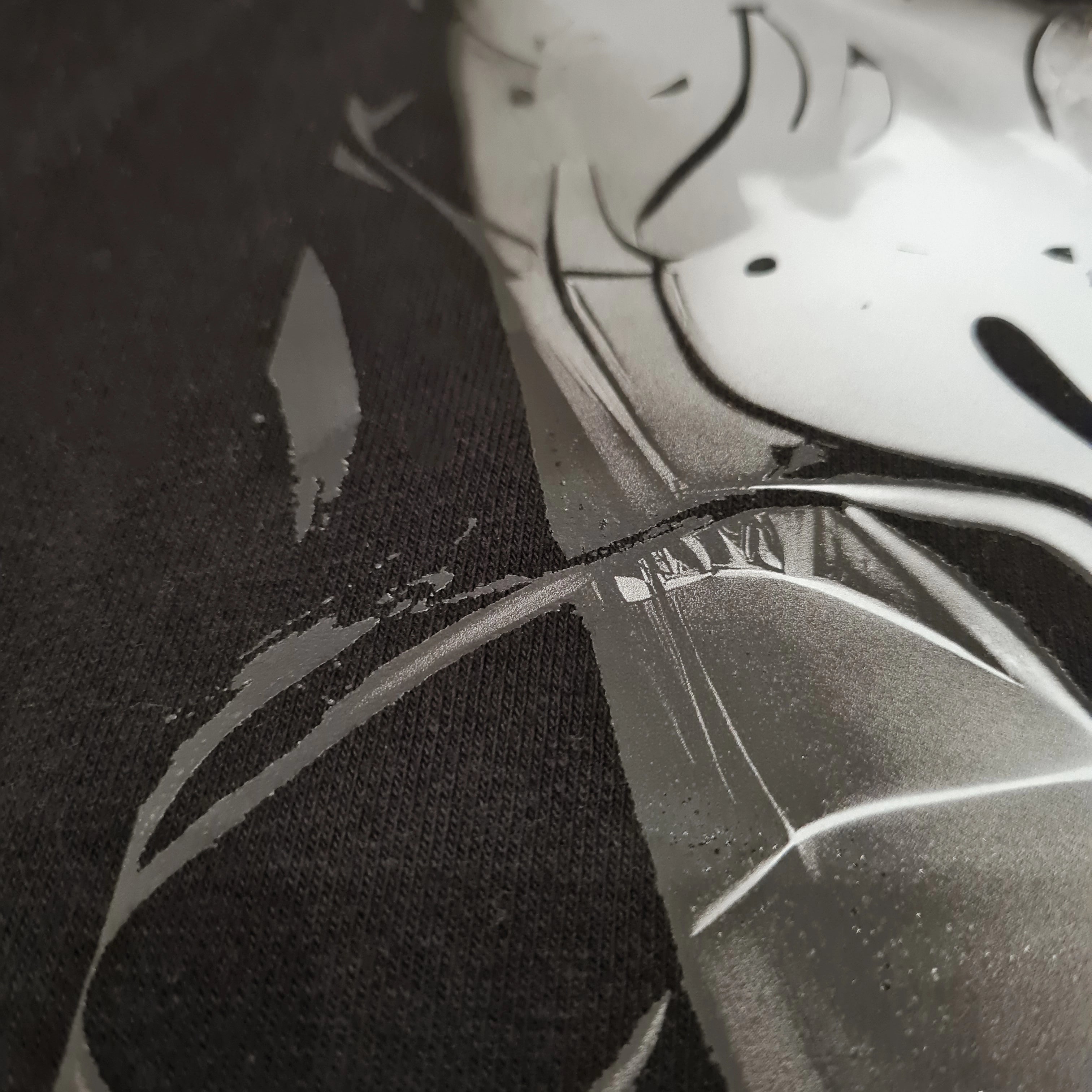 Close-up of a black sock with a white shoe design on a dark background