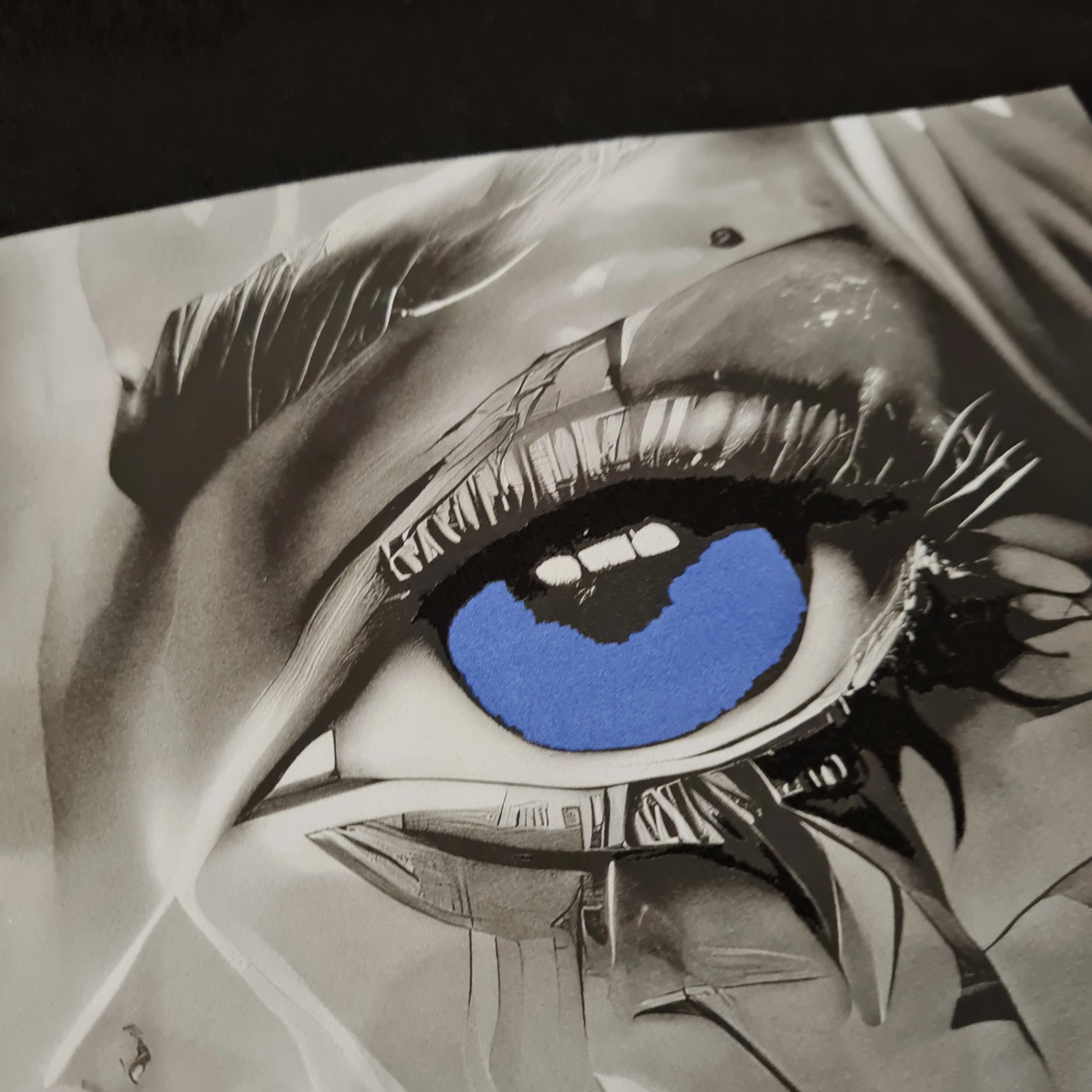 Artistic depiction of a close-up eye with blue reflection, surrounded by black and white elements.