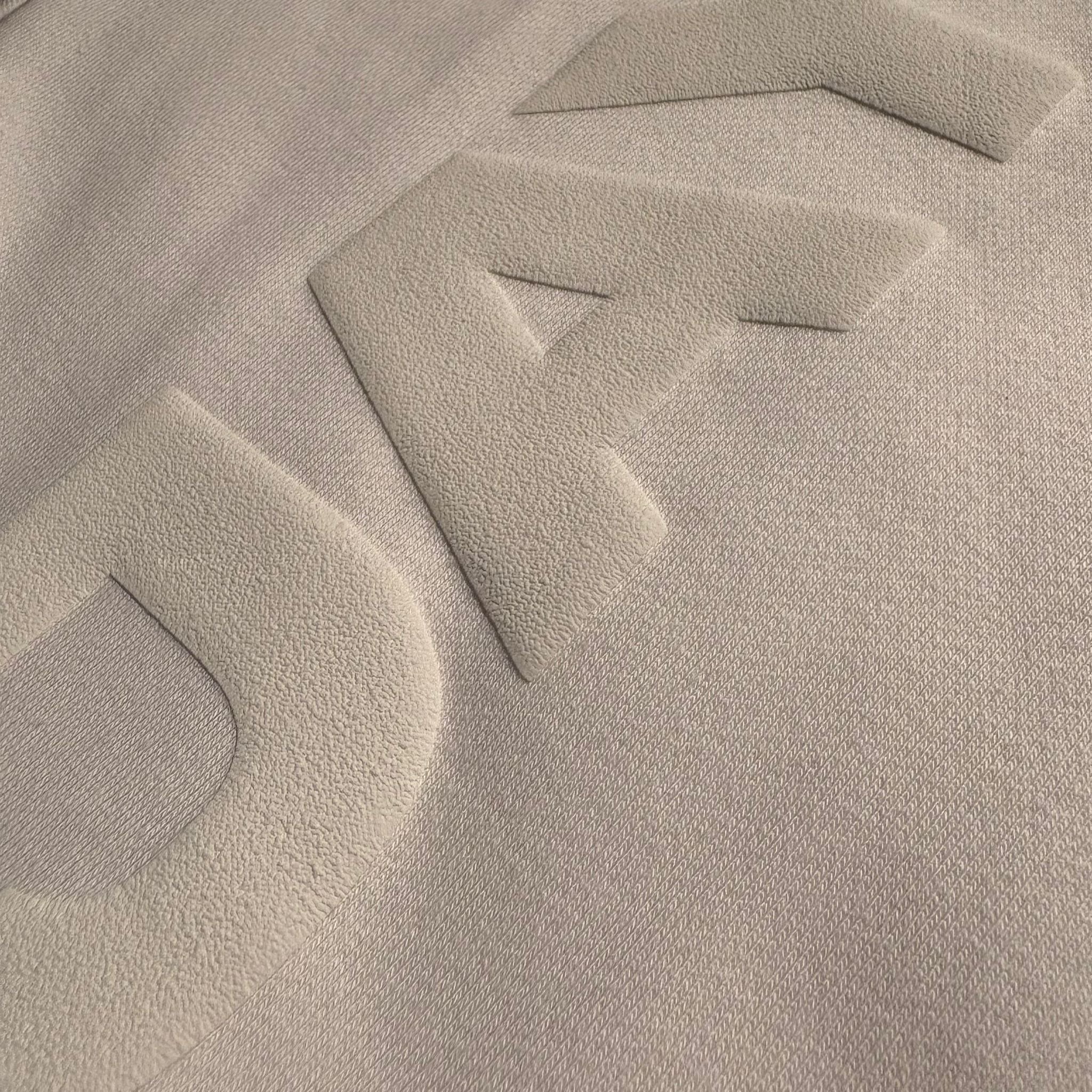 Close-up of a textured beige fabric surface with geometric patterns.