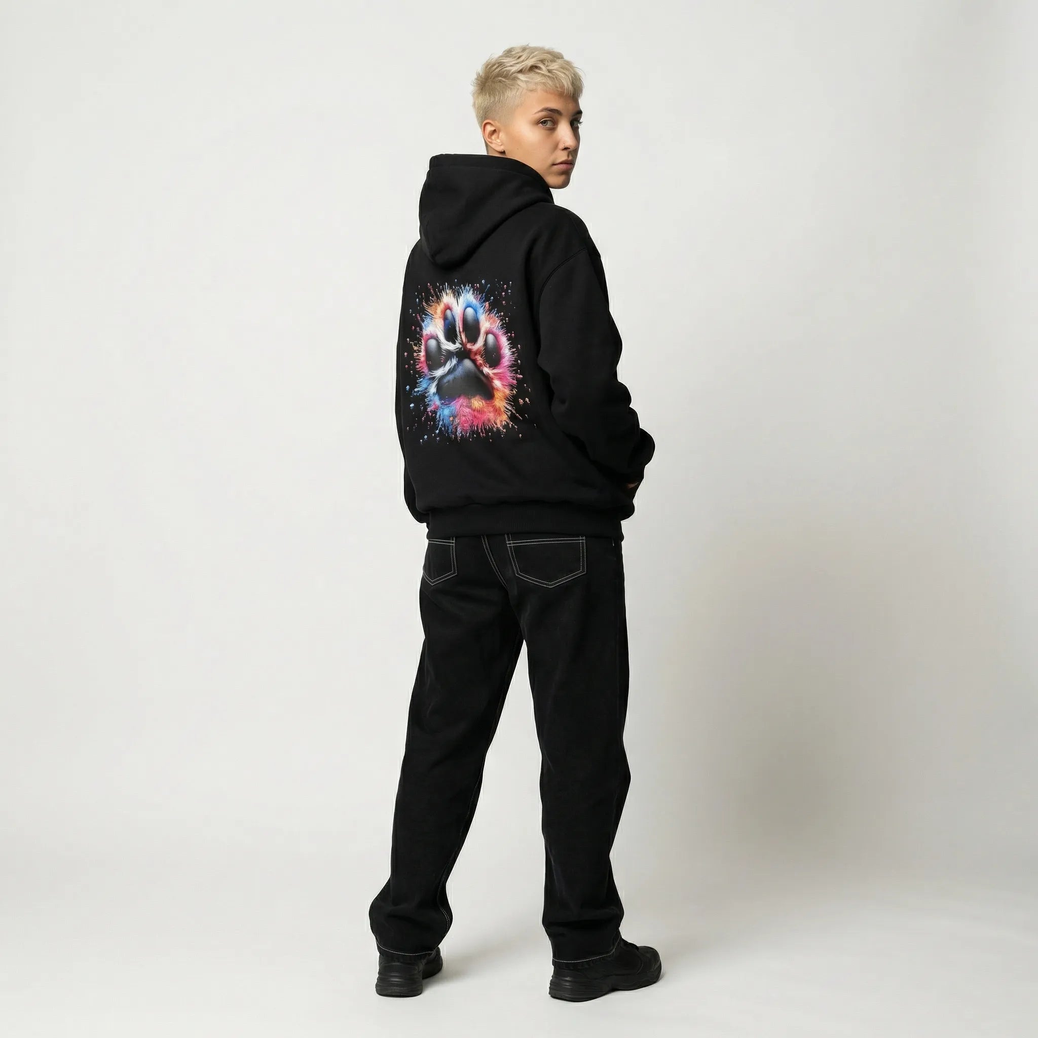 Person wearing a black hoodie with a colorful graphic on the back against a white background