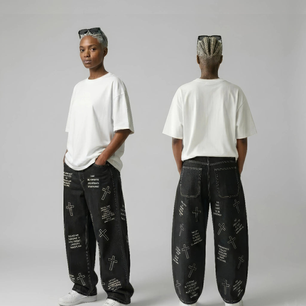 Person wearing black pants with white text and graphics, standing against a plain background