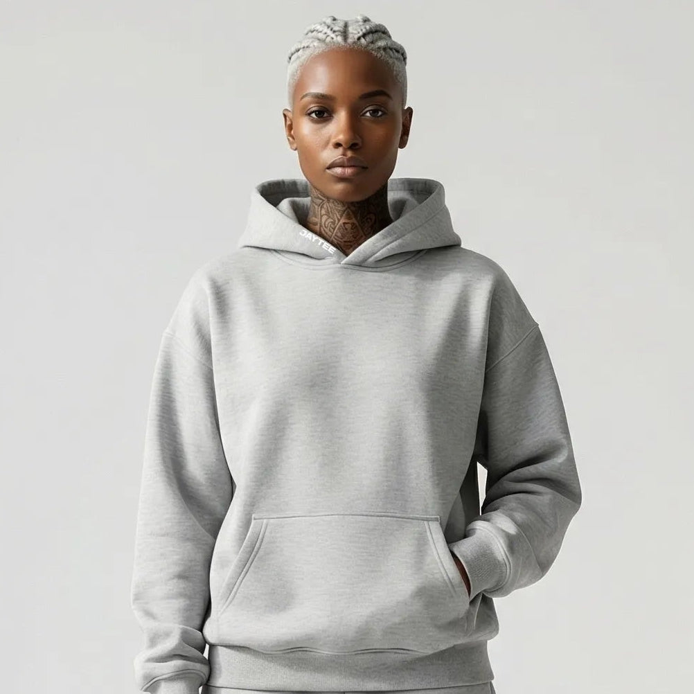 Person wearing a gray JAYTEE hoodie and shorts set on a white background