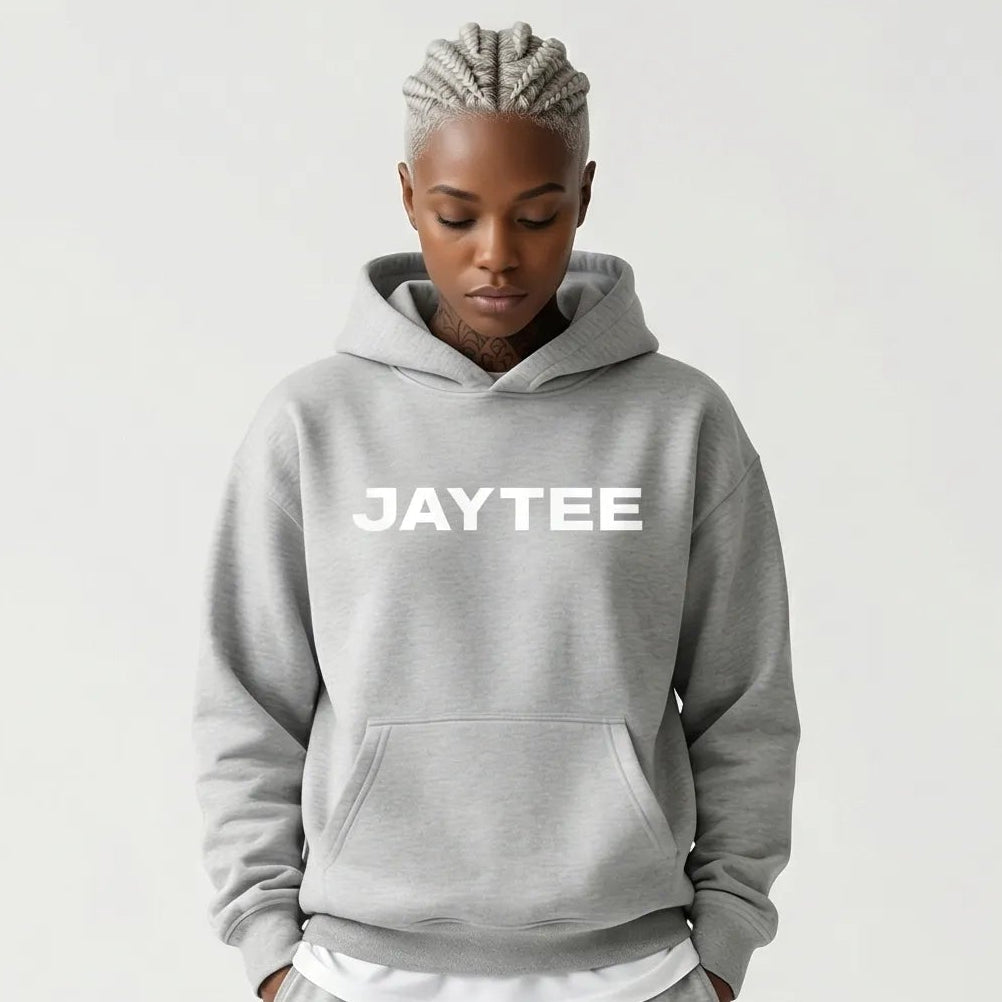 Person wearing a gray JAYTEE hoodie and pants on a white background