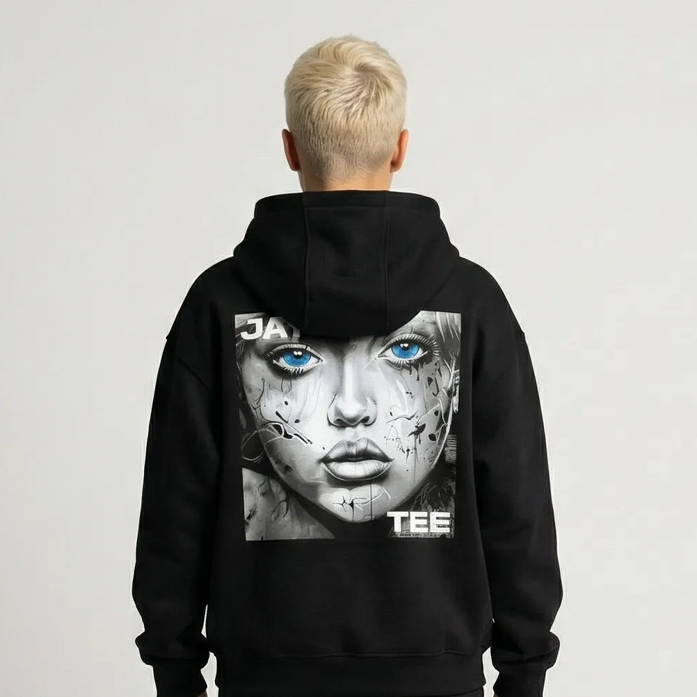 Person wearing a black JAYTEE hoodie with a graphic design on the back against a plain background