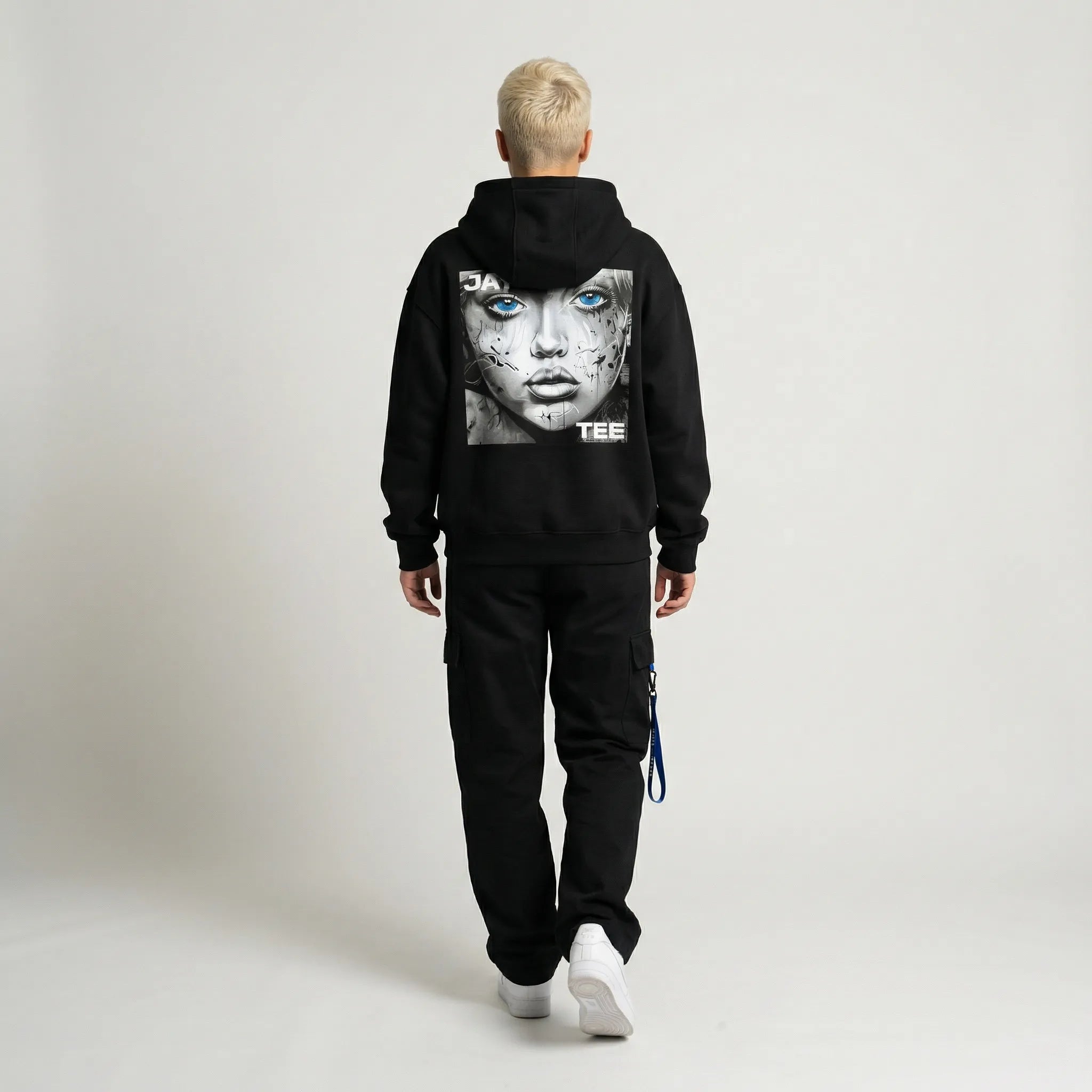 Person wearing a black hoodie with a graphic design on the back against a plain background