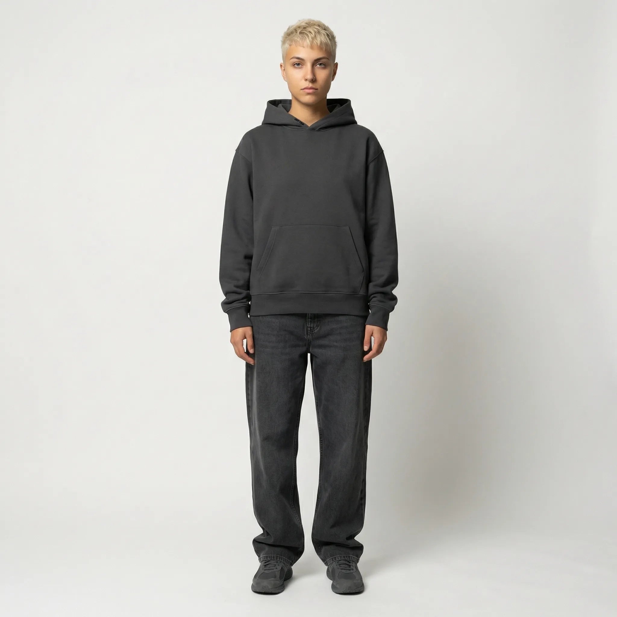 Person wearing a dark gray hoodie and pants on a white background