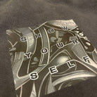 Close-up of a watch with text on the dial, worn on a dark fabric background