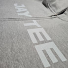 Gray hoodie with 'JAYTEE' branding on a plain background