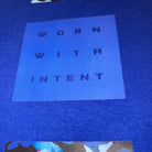 Blue label with 'WORN WITH INTENT' text on a blue background