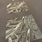 Close-up of a black t-shirt with graphic design and text on a dark background