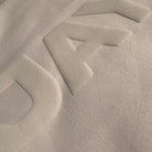 Close-up of a textured beige fabric surface with geometric patterns.