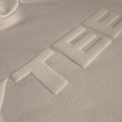 Close-up of a textured surface with embossed letters spelling 'JAYTEE'.