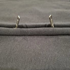 Close-up of gray fabric with metal grommets on a textured background