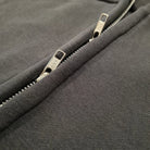 Close-up of a zipper on a dark gray fabric background
