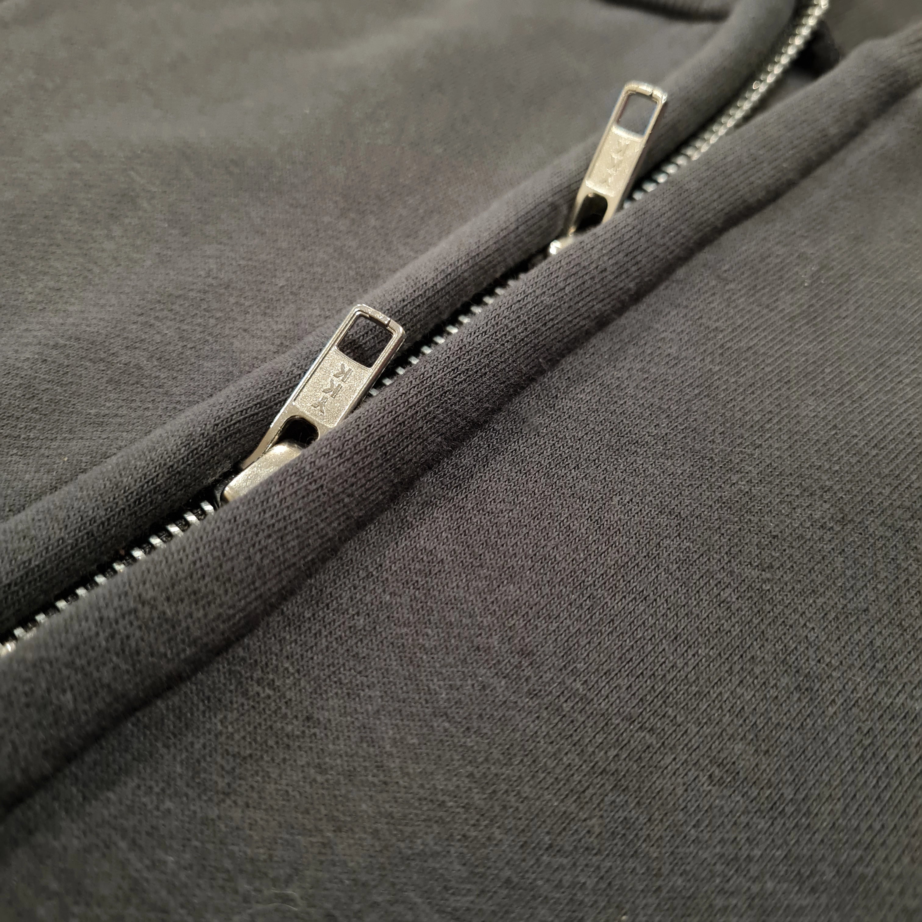 Close-up of a zipper on a dark gray fabric background