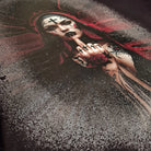 Artistic depiction of a woman with dark makeup and a red hood, holding her finger to her lips.