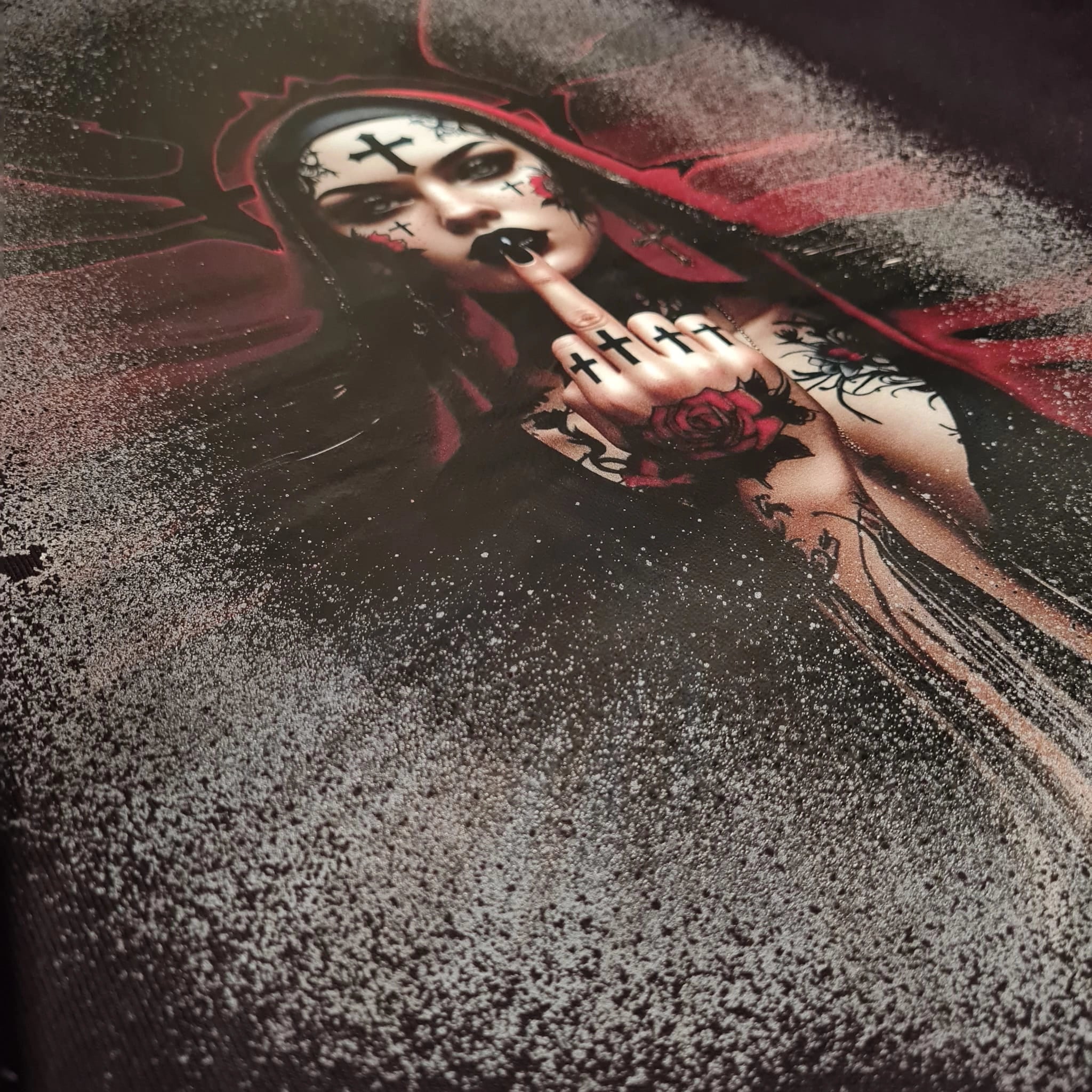 Artistic depiction of a woman with dark makeup and a red hood, holding her finger to her lips.