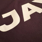 Close-up of a brown fabric with 'JACK' printed in white.