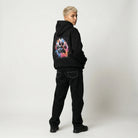 Person wearing a black hoodie with a colorful graphic on the back against a white background