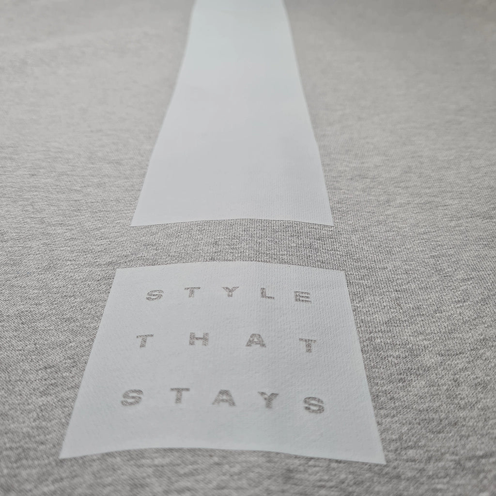 Gray fabric with a white label reading 'STYLE THAT STAYS' on a matching gray background