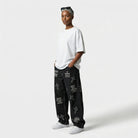 Person wearing a white t-shirt and black pants with text and cross designs on a white background