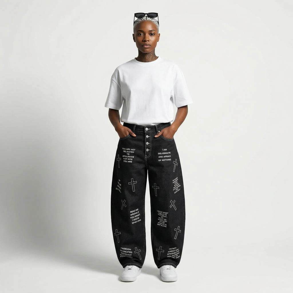 Person wearing black jeans with text and cross patterns on a white background