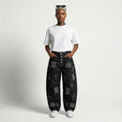 Person wearing black jeans with text and cross patterns on a white background