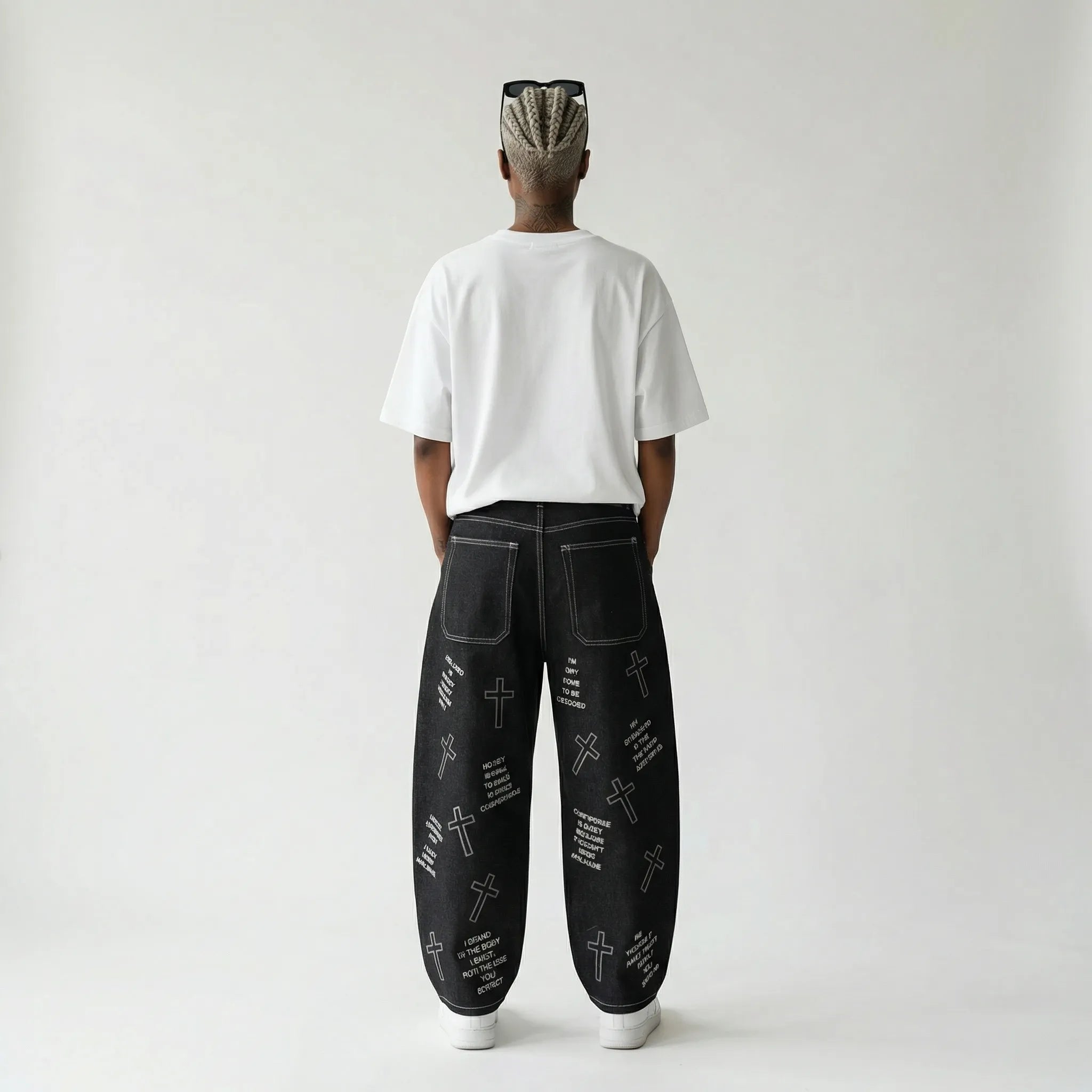 Person wearing black pants with white patterns on a plain background, view from back