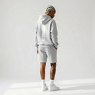 Person wearing a gray JAYTEE  hoodie and shorts set on a white background