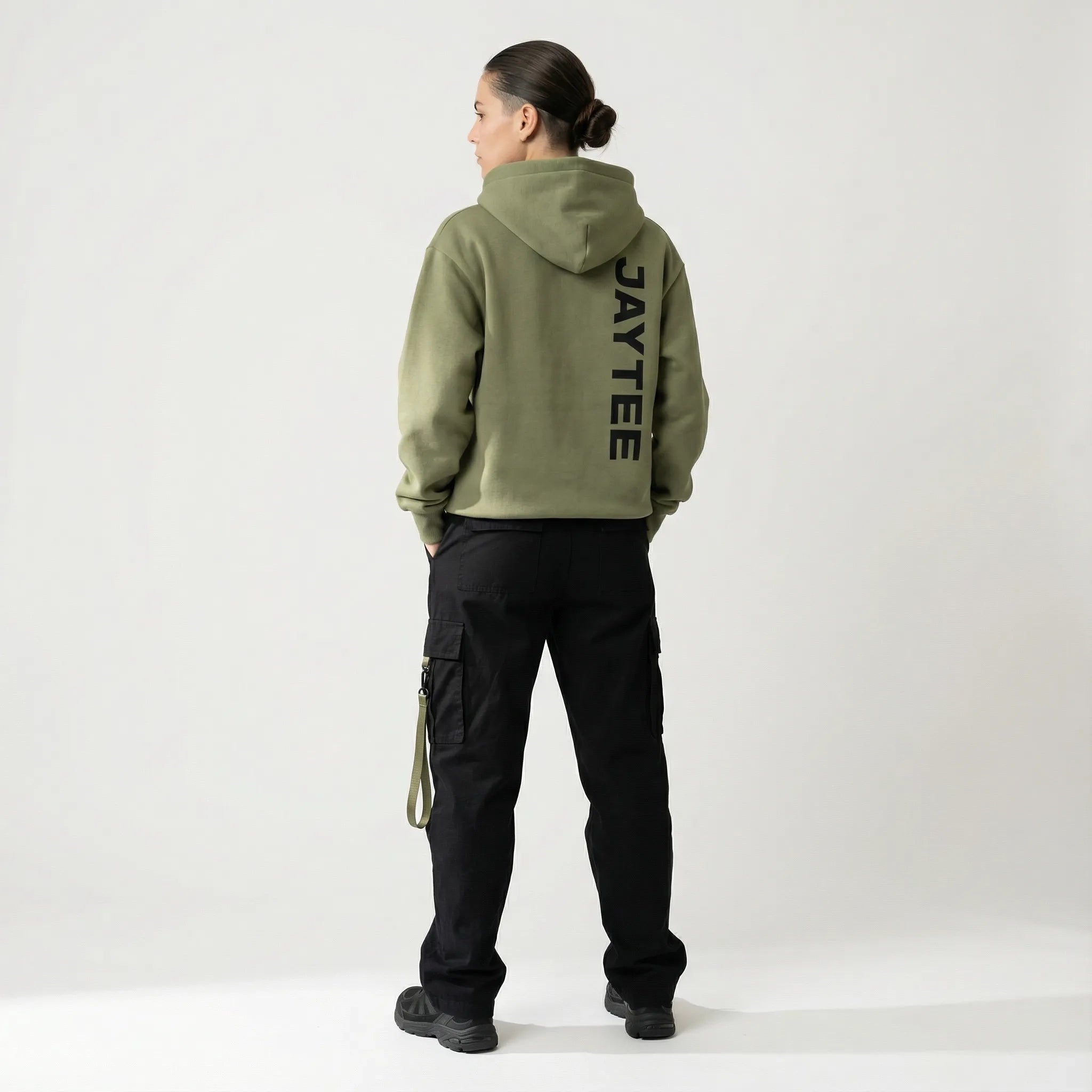 Person wearing a green hoodie with JAYTEE branding on the back, standing against a white background.