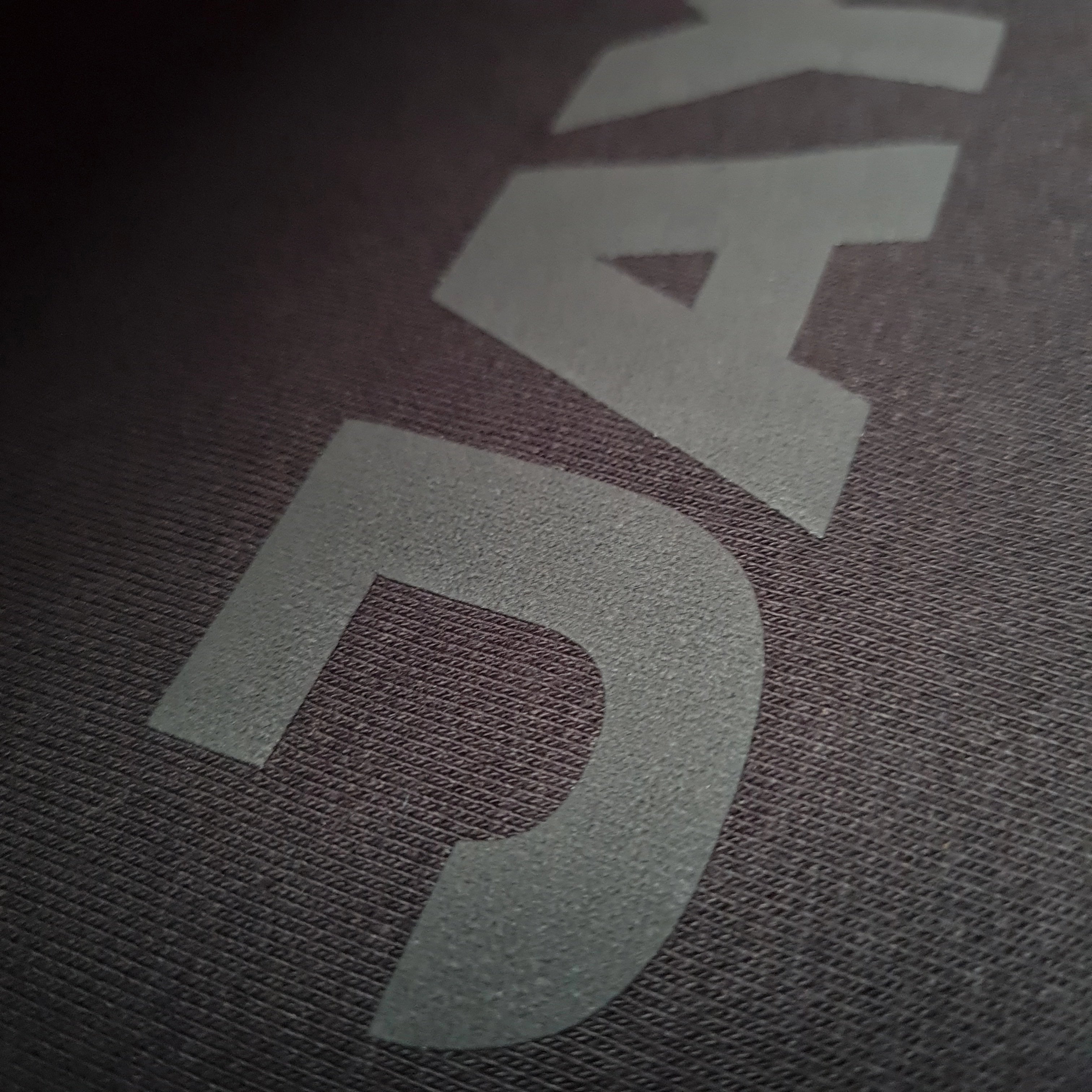 Close-up of a textured surface with  JAYTEE branding.