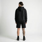 Person wearing a black hoodie with 'AYTEE branding on the back, standing against a white background.