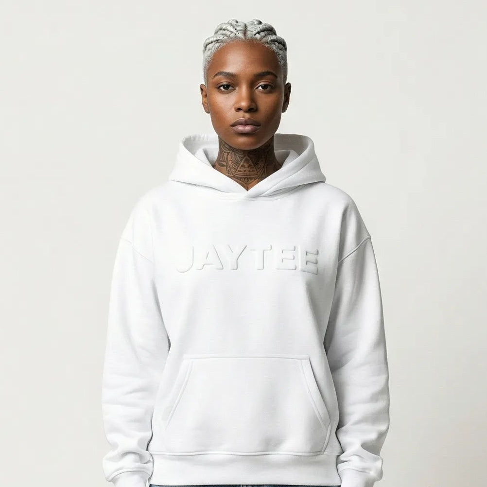 Person wearing a white JAYTEE hoodie and ripped jeans on a plain background
