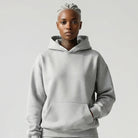 Person wearing a gray JAYTEE hoodie and shorts set on a white background