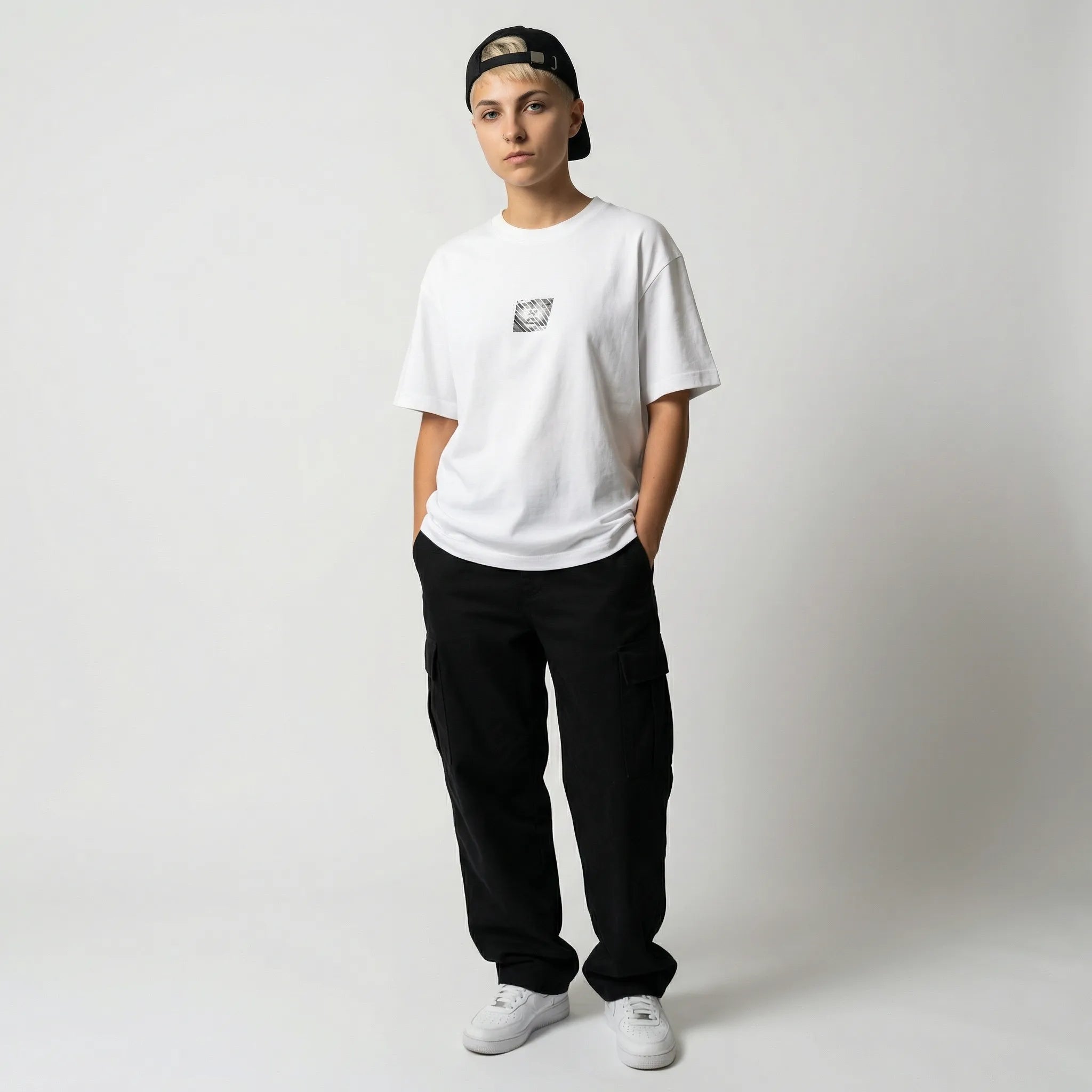 Person wearing a white JAYTEE t-shirt, black pants, and a cap on a plain background