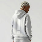 Person wearing a gray JAYTEE hoodie and shorts set on a white background