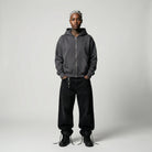 Person wearing a gray JAYTEE hoodie and black pants on a plain background