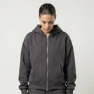 Person wearing a dark gray JAYTEE hoodie and cargo pants on a white background