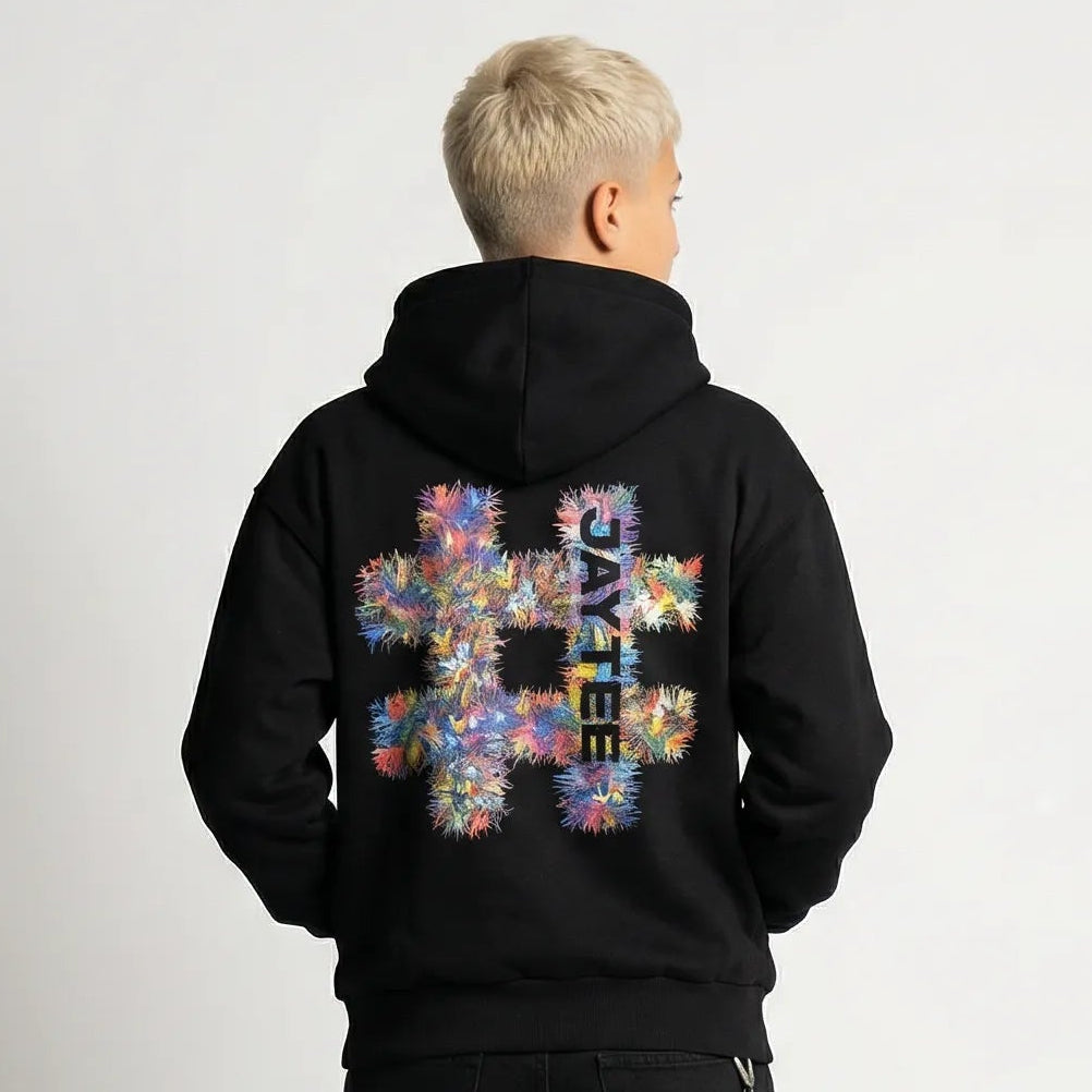 Person wearing a black JAYTEE hoodie with a colorful hashtag design on the back, standing against a plain background.