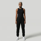 Person wearing a black sleeveless top and black  JAYTEE pants on a light gray background