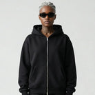 Person wearing a black JAYTEE hoodie and pants holding a red and black patterned bandana on a white background