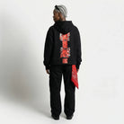Person wearing a black  JAYTEE hoodie with red and white design on the back, standing against a plain background.