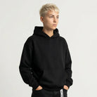 Person wearing a black JAYTEE hoodie and black pants with white text on a white background