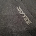 Close-up of a textured gray fabric with 'JAYTEE' branding.