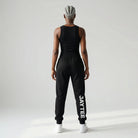 Person wearing a black JAYTEE tracksuit on a white background