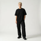 Person wearing a black JAYTEE outfit on a white background