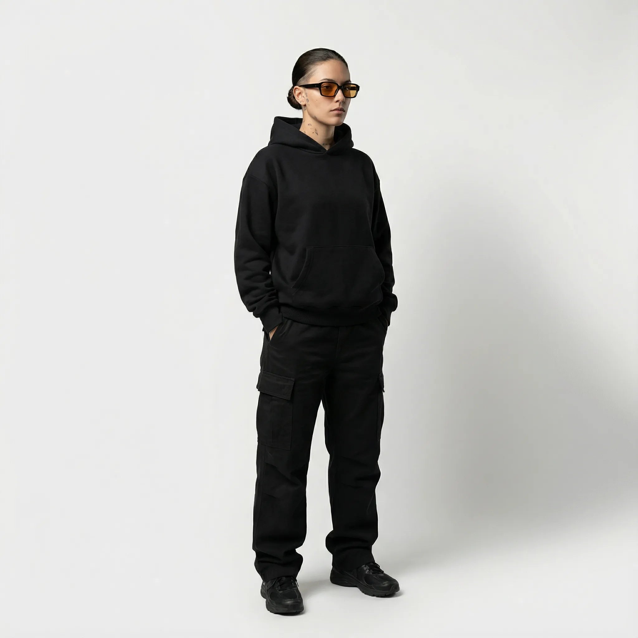 Person wearing a black JAYTEE hoodie and pants on a white background